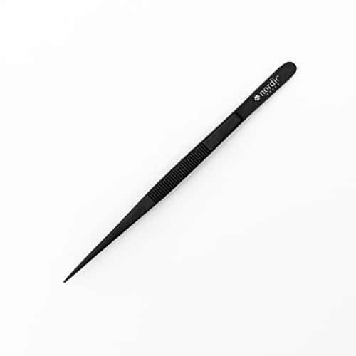 Pinzas metálicas de precisión negras sobre fondo blanco.