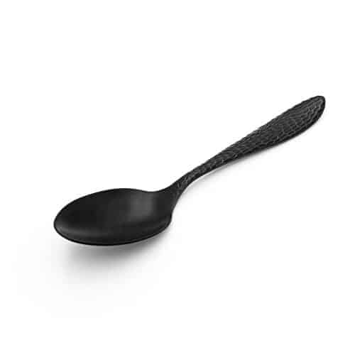 Cuillère noire texturée sur fond blanc.