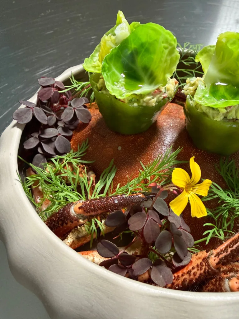 Green cucumber jelly croustades filled with crab and garnished with Brussels sprout leaves